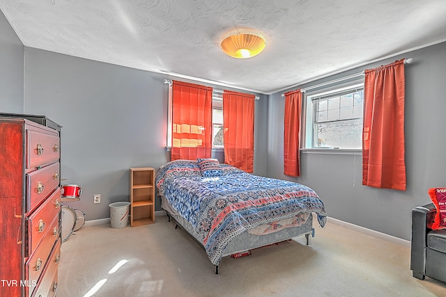 carpeted bedroom with a textured ceiling and multiple windows