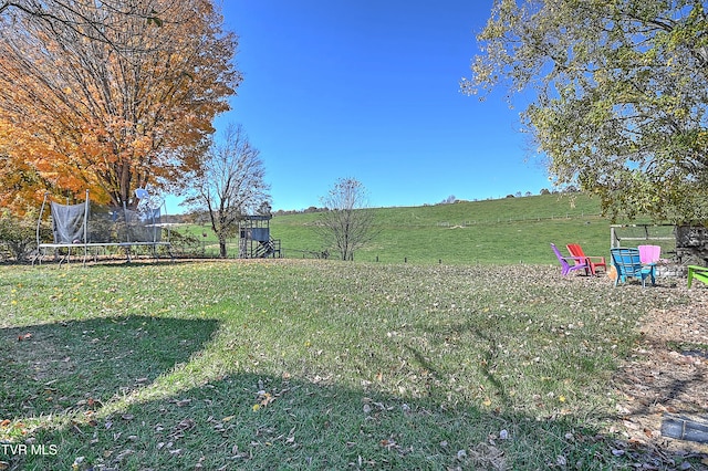 view of yard with a trampoline and a rural view