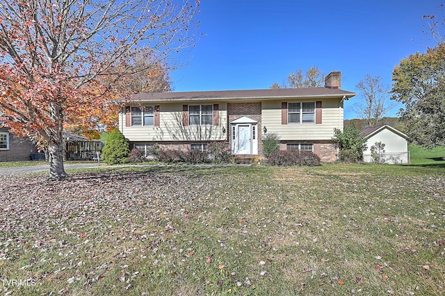 bi-level home featuring a storage unit and a front yard