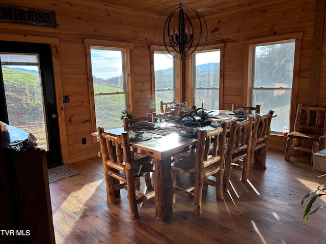 dining space featuring dark hardwood / wood-style flooring, wood walls, and plenty of natural light