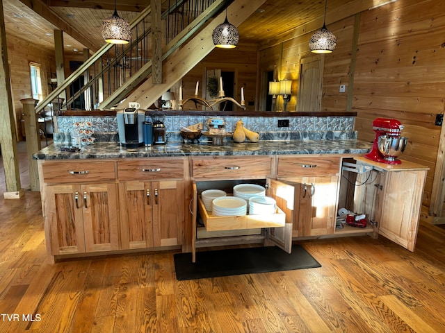 kitchen with decorative light fixtures, wood-type flooring, and wood walls