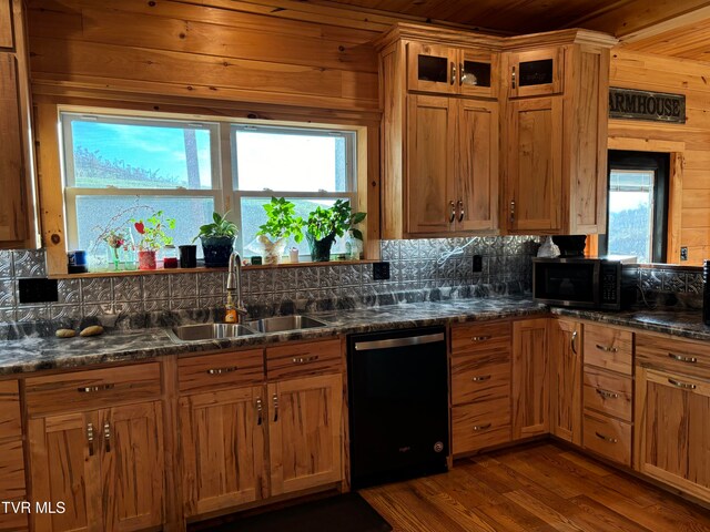 kitchen with black dishwasher, sink, plenty of natural light, and dark stone counters