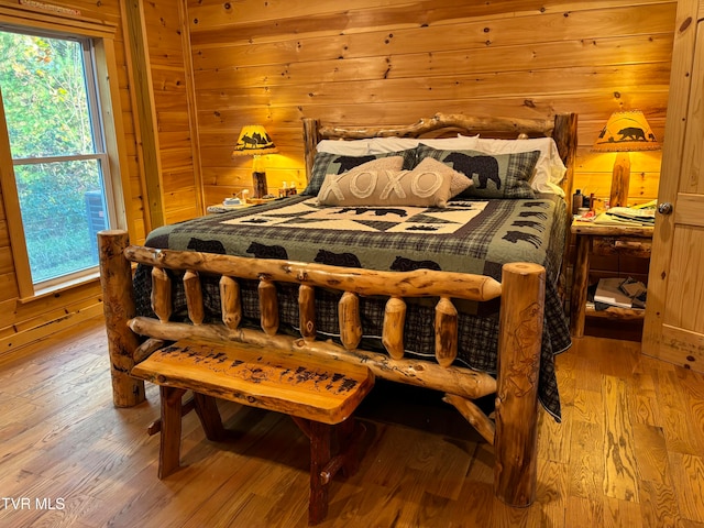 bedroom featuring hardwood / wood-style floors and wooden walls