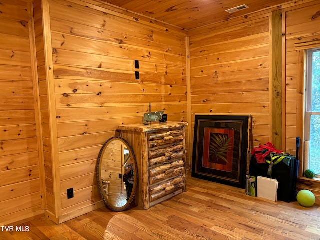 sitting room with wooden walls and light hardwood / wood-style floors