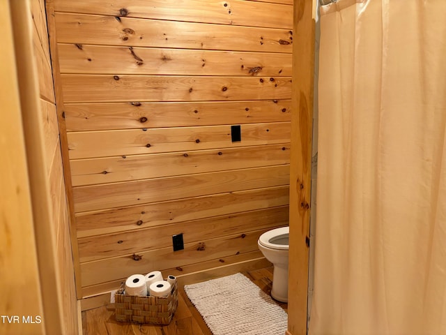 bathroom with toilet and wooden walls