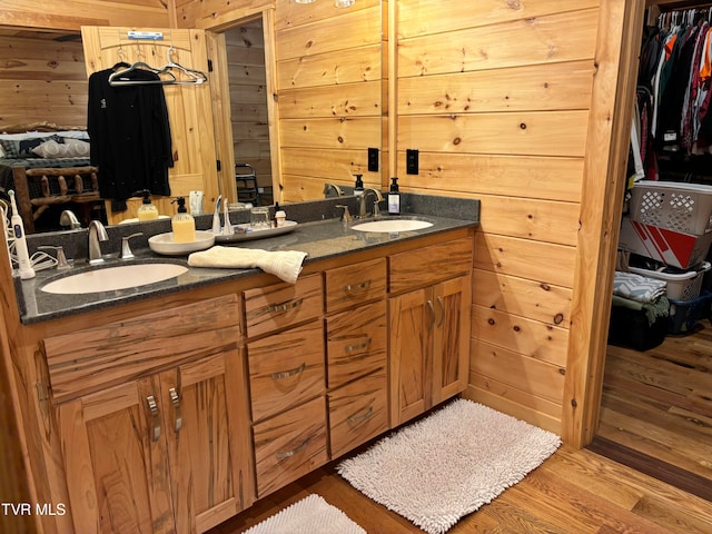 bathroom featuring vanity, wood-type flooring, and wooden walls