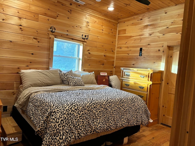 bedroom featuring wooden ceiling, wooden walls, and hardwood / wood-style floors