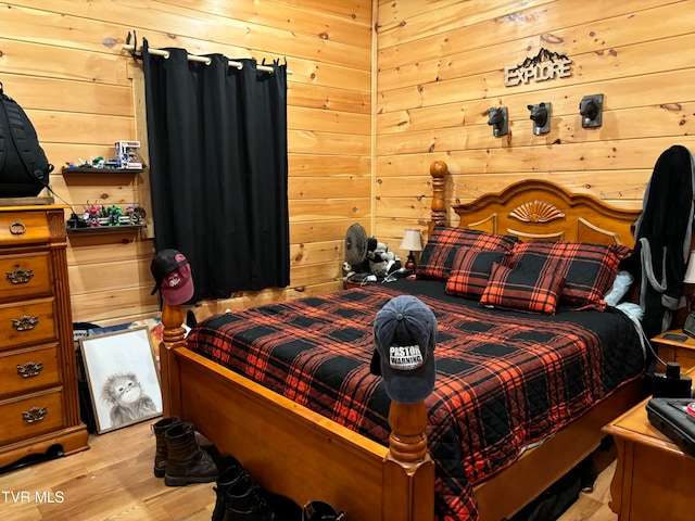 bedroom featuring wooden walls and light wood-type flooring