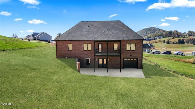 back of property with a patio area, a lawn, and a mountain view