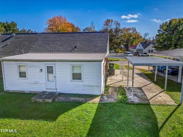 rear view of house featuring metal roof, a lawn, and cooling unit