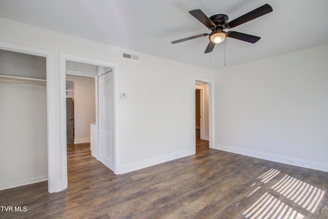 unfurnished bedroom featuring visible vents, baseboards, a closet, and dark wood-style flooring