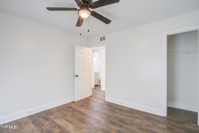 unfurnished bedroom with a closet, baseboards, visible vents, and wood finished floors