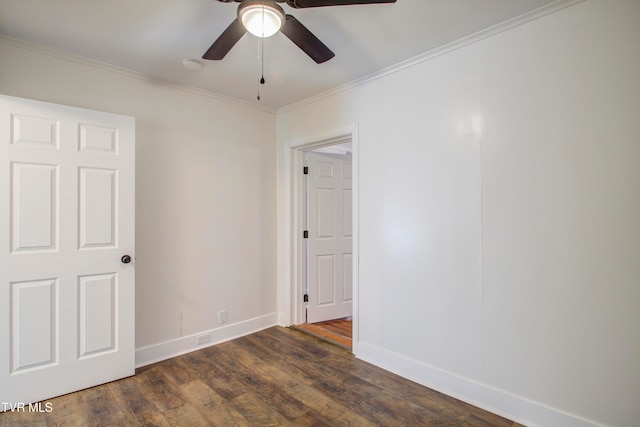 empty room with dark wood finished floors, crown molding, baseboards, and ceiling fan