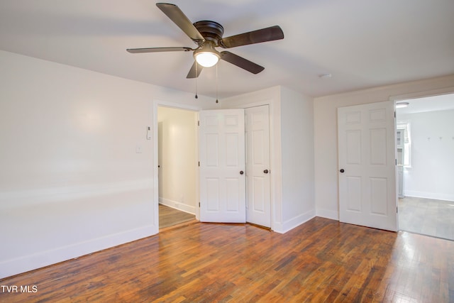 unfurnished bedroom with a closet, a ceiling fan, baseboards, and wood-type flooring