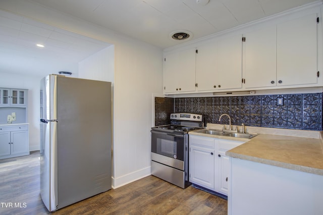 kitchen featuring visible vents, backsplash, wood finished floors, stainless steel appliances, and a sink