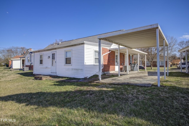 view of side of home with central AC unit, a yard, and a patio area