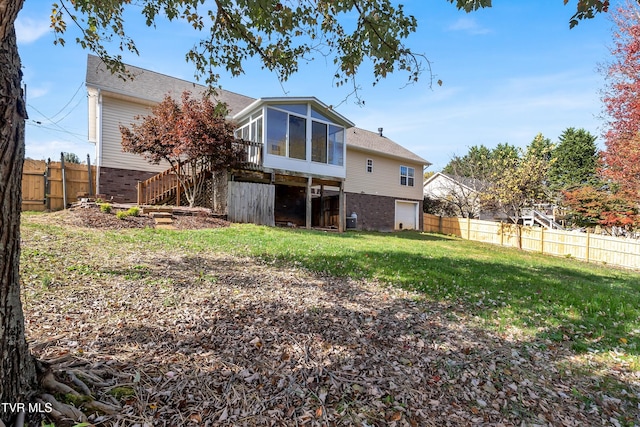 rear view of house with central air condition unit, a sunroom, and a lawn