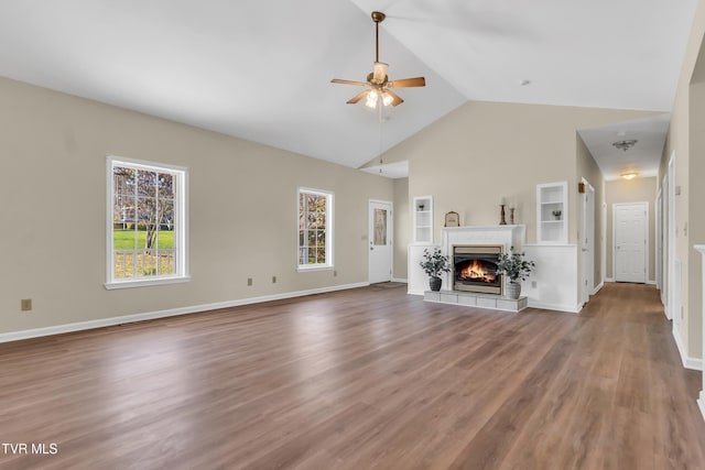 unfurnished living room featuring lofted ceiling, hardwood / wood-style floors, a wealth of natural light, and ceiling fan