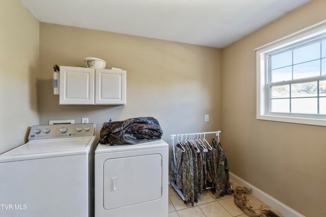 laundry area with light tile patterned flooring, washing machine and dryer, and cabinets