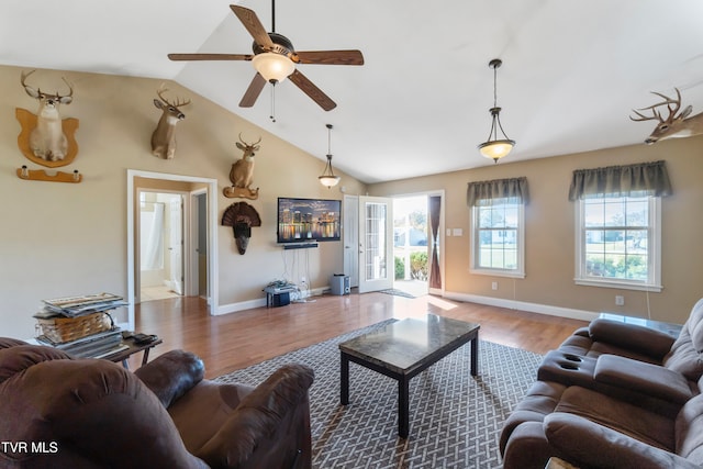 living room featuring ceiling fan, hardwood / wood-style flooring, and vaulted ceiling