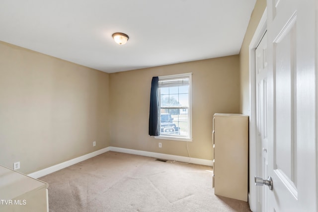 unfurnished room featuring light carpet