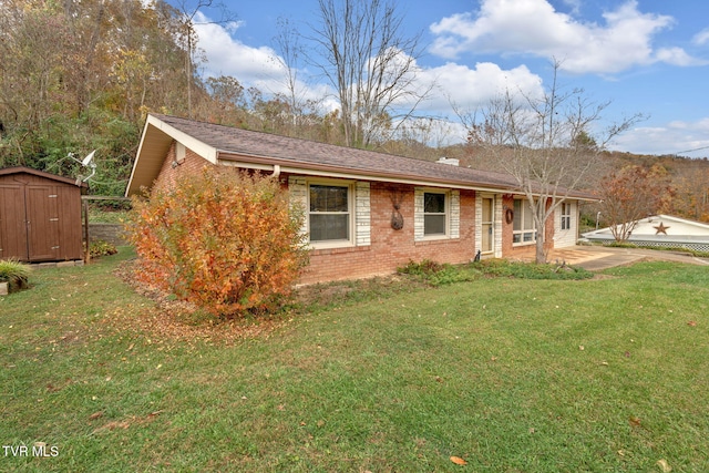 ranch-style home with a front yard and a storage unit