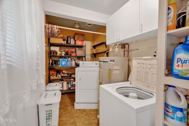 laundry area with water heater, washing machine and dryer, cabinets, and light tile patterned floors