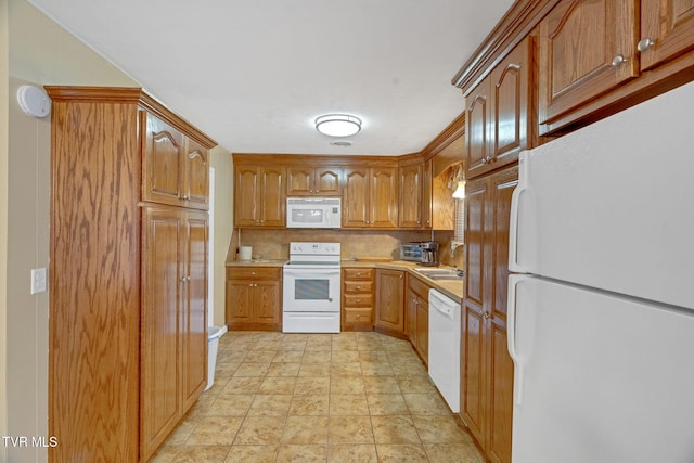 kitchen featuring white appliances, sink, pendant lighting, and tasteful backsplash