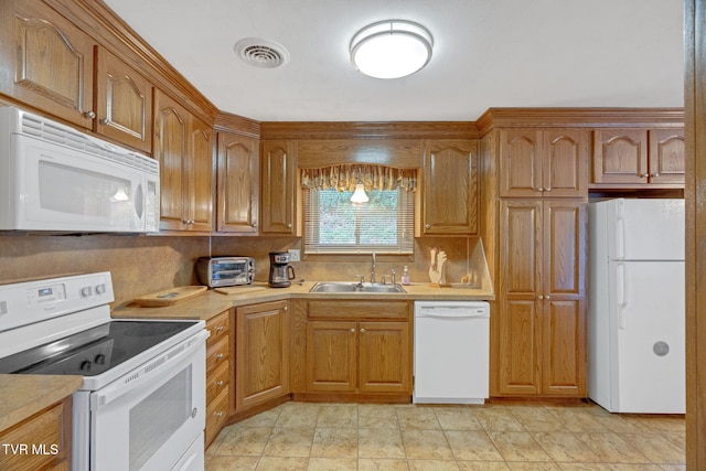 kitchen featuring white appliances, sink, and light tile patterned flooring