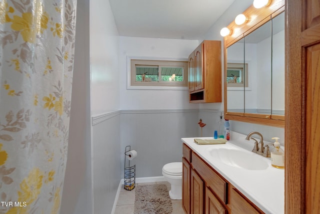 bathroom with toilet, vanity, and tile patterned floors