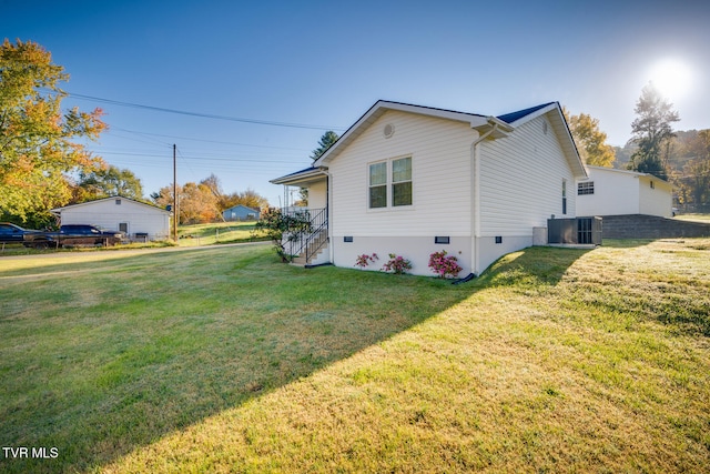 view of side of home with a lawn and central AC unit