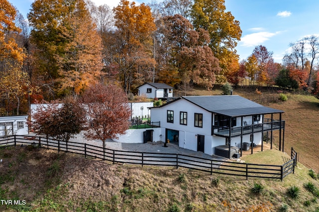 rear view of house with a lawn and a rural view