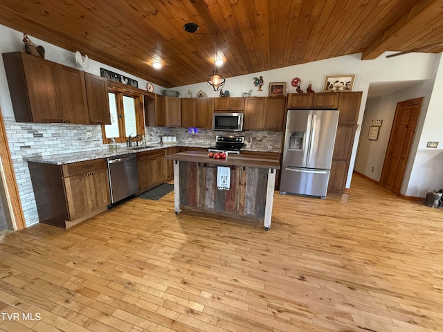 kitchen featuring light hardwood / wood-style flooring, lofted ceiling, stainless steel appliances, and a kitchen island