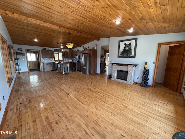 unfurnished living room with a stone fireplace, light hardwood / wood-style flooring, wooden ceiling, lofted ceiling with beams, and ceiling fan