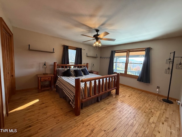 bedroom featuring light hardwood / wood-style flooring, multiple windows, and ceiling fan