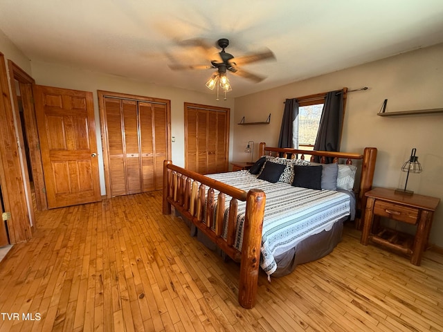 bedroom featuring ceiling fan, multiple closets, and light wood-type flooring