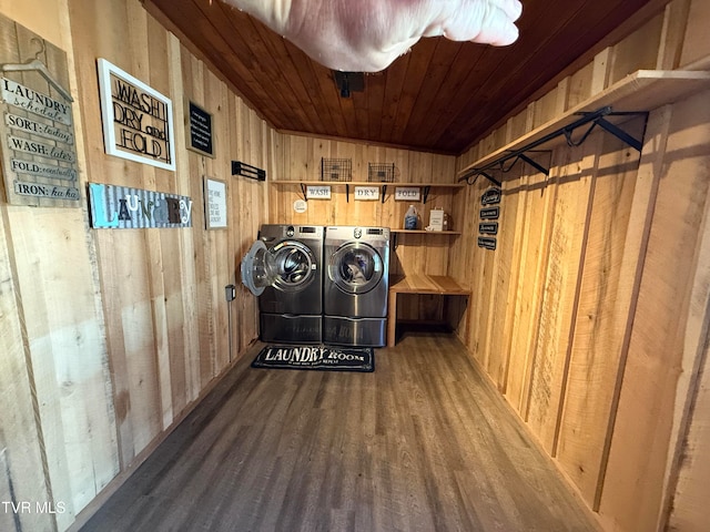 laundry room featuring hardwood / wood-style flooring, wood walls, washing machine and dryer, and wooden ceiling