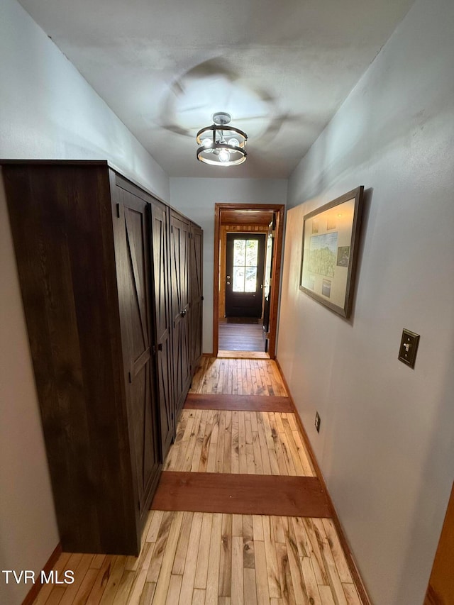 hall featuring a chandelier and light wood-type flooring