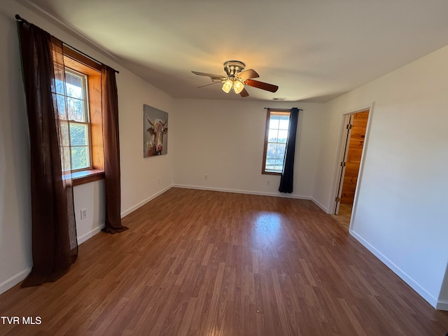 unfurnished room with dark hardwood / wood-style floors, ceiling fan, and a wealth of natural light