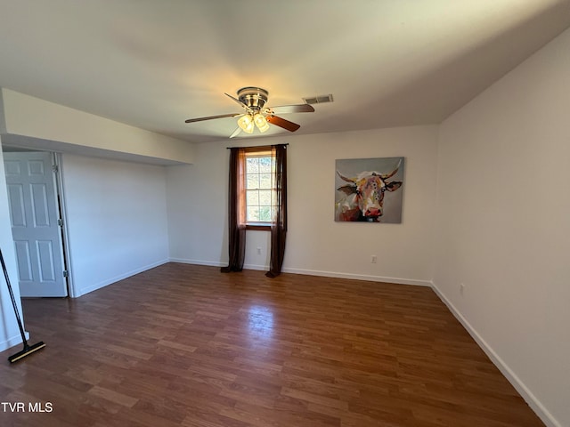 empty room with ceiling fan and dark hardwood / wood-style flooring