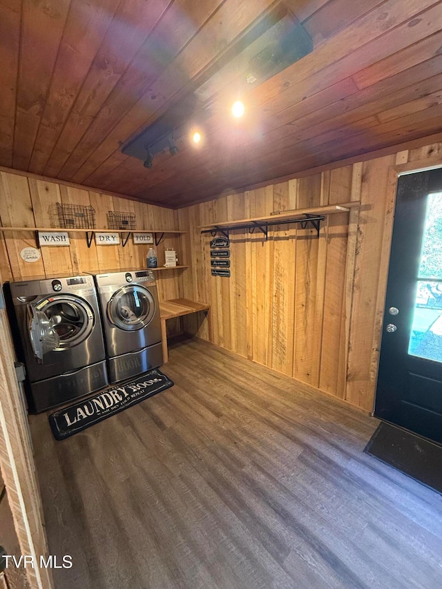 laundry room with hardwood / wood-style flooring, wooden walls, wooden ceiling, and washer and clothes dryer