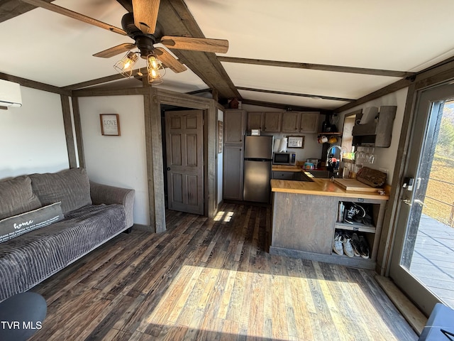 kitchen with appliances with stainless steel finishes, sink, lofted ceiling with beams, ceiling fan, and dark wood-type flooring