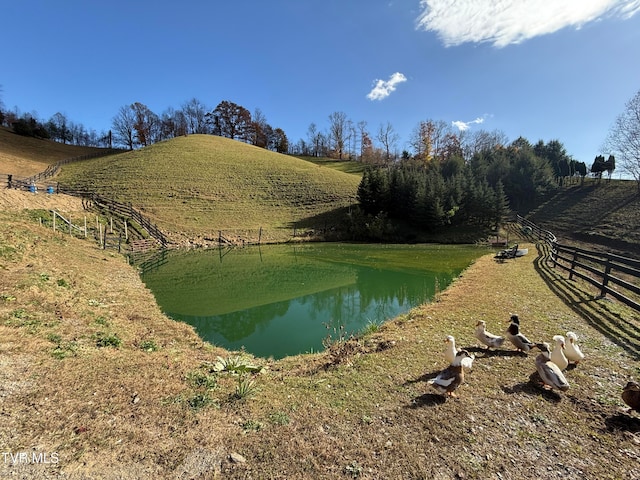 view of property's community featuring a water view, a rural view, and a yard