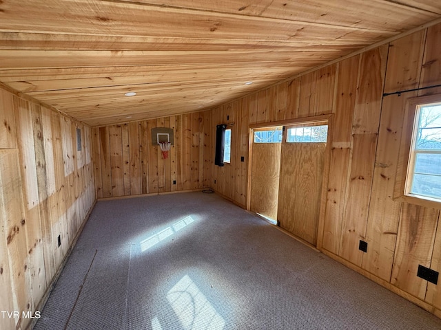 spare room featuring lofted ceiling, wood walls, and wooden ceiling