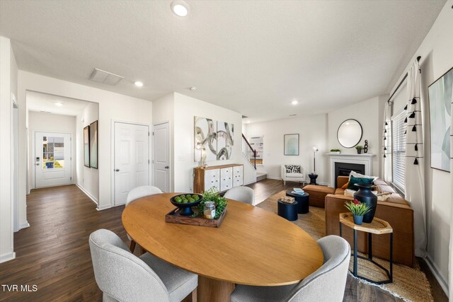 dining space featuring a textured ceiling and dark hardwood / wood-style flooring