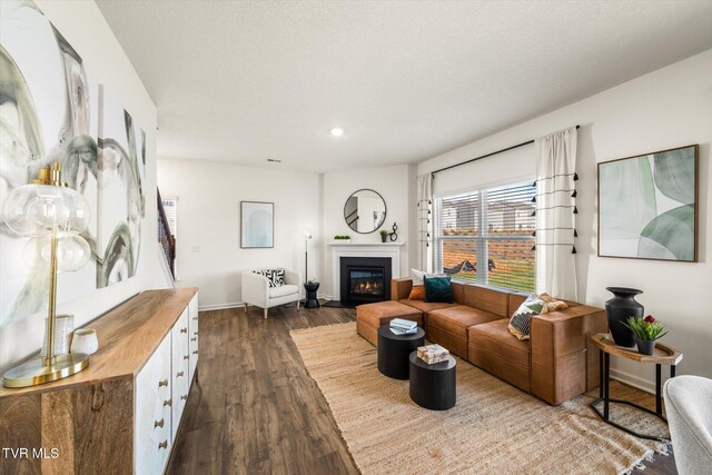 living room featuring a textured ceiling and dark hardwood / wood-style floors