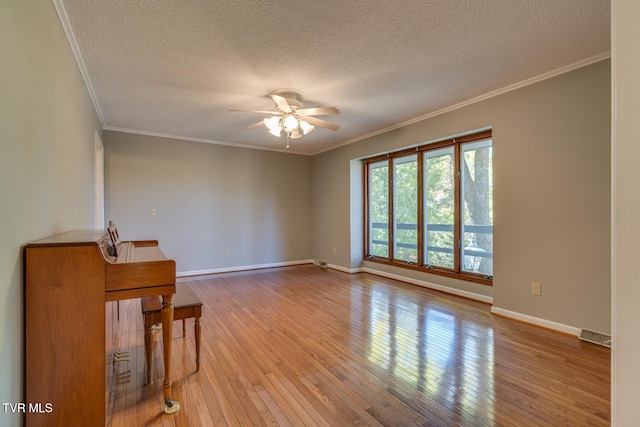 spare room with light hardwood / wood-style floors, crown molding, a textured ceiling, and ceiling fan