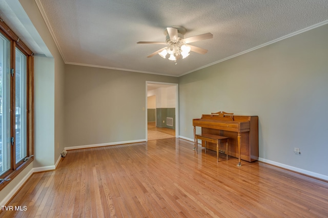 empty room featuring ornamental molding, a textured ceiling, light hardwood / wood-style floors, and ceiling fan