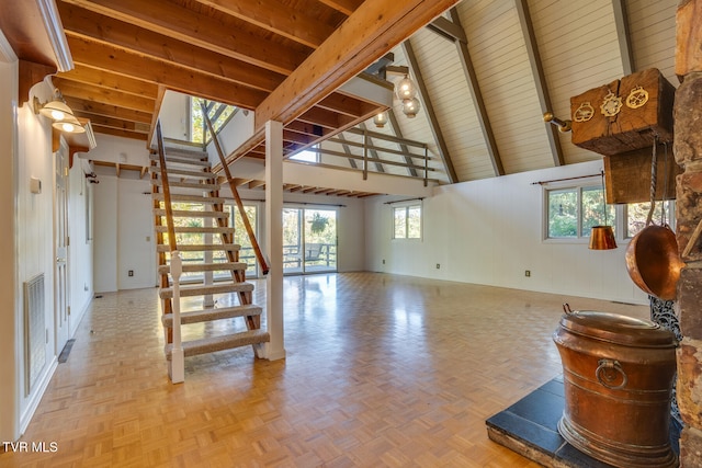 interior space with wood walls, parquet flooring, wood ceiling, beam ceiling, and high vaulted ceiling