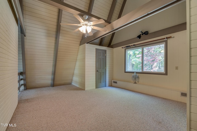 unfurnished bedroom with lofted ceiling with beams, light colored carpet, and wooden walls